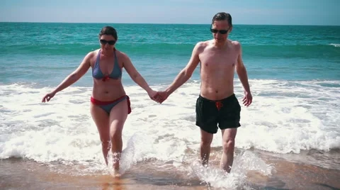 Happy Couple Having Fun on Ocean Waves Stock Footage 55450049