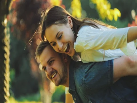 Happy Couple Having Fun Outdoors. SLOW MOTION 4K. Man and woman doing piggyback 動画素材 77816984