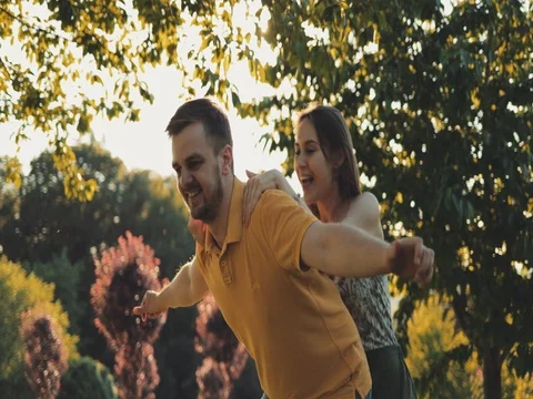 Happy Couple Having Fun Outdoors. SLOW MOTION 4K. Man and woman doing piggyback Stock Footage 77817027