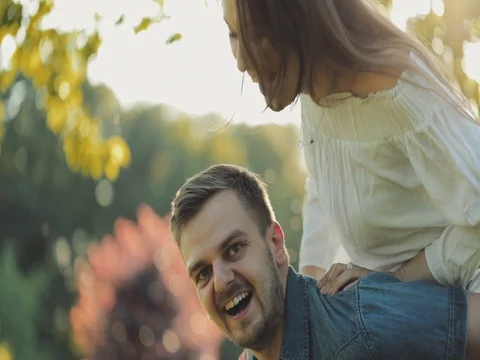 Happy Couple Having Fun Outdoors. SLOW MOTION 4K. Man and woman doing piggyback Stock Footage