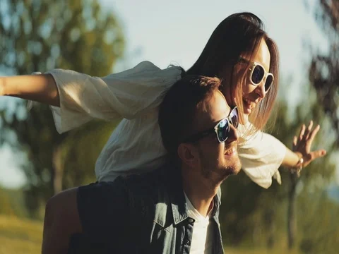 Happy Couple Having Fun Outdoors. SLOW MOTION 4K. Man and woman doing piggyback Stock Footage 77817341