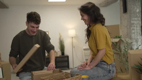 Happy couple having fun while unpack boxes together and drink coffee Stock Footage 308936637