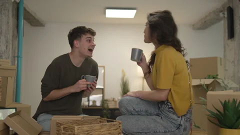 Happy couple having fun while unpack boxes together and drink coffee Stock Footage 308936721