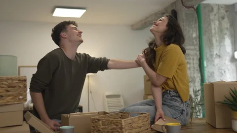 Happy couple having fun while unpack boxes together and drink coffee Stock Footage 308936724