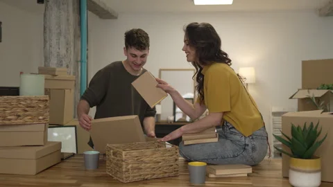 Happy couple having fun while unpack boxes together and drink coffee Stock Footage 308936726