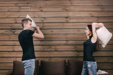 Happy couple having pillow fight in hotel room Stock Photos