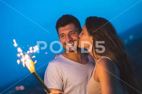 The happy couple hold a firework stick. evening night time Stock Photos