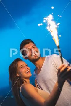 The happy couple hold a firework stick. evening night time Stock Photos