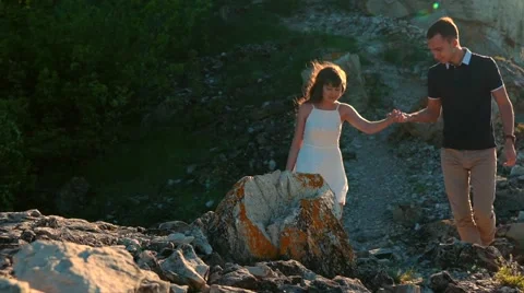 Happy couple holding hands walking in the mountains 스톡 동영상 64017853