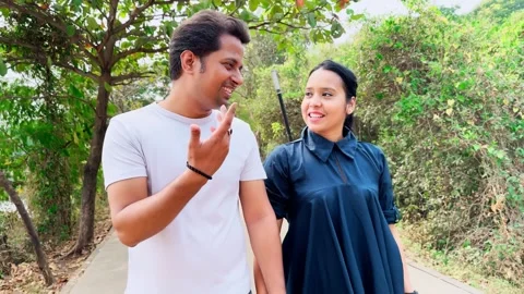 Happy Couple holding hands while walking talking on a path with city skylin.. Stock Footage 263488118