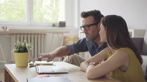 Happy couple at home together browsing internet on laptop Stock Footage