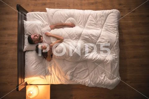 The happy couple hug on the bed. view from above Stock Photos