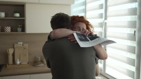 Happy couple hugging after seeing ultrasound scan 스톡 동영상 333262049