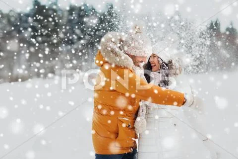 Happy couple hugging and laughing in winter Stock Photos