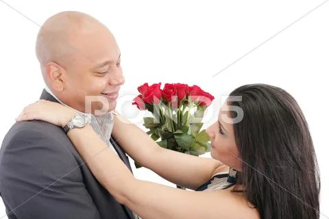 Happy couple hugging with a bouquet of red roses in the middle. valentine Stock Photos