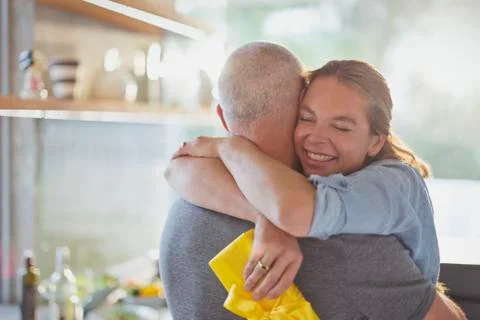 Happy couple hugging in kitchen Stock Photos