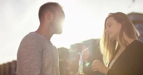 Happy couple joyfully drinking out of one bottle with a straw Video stock 79088148