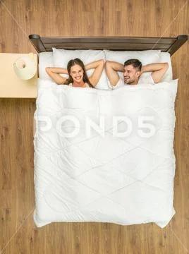 The happy couple lay on the bed. View from above Stock Photos