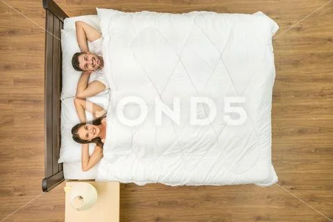 The happy couple lay on the bed. View from above Stock Photos