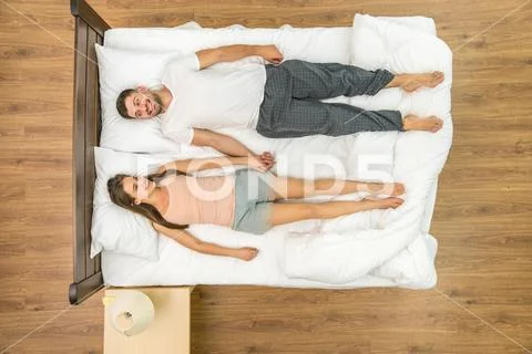 The happy couple lay on the bed. View from above Stock Photos