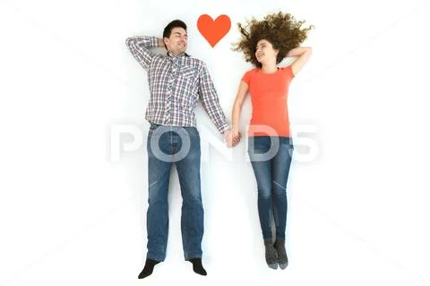 The happy couple lay near the heart sign. View from above Stock Photos