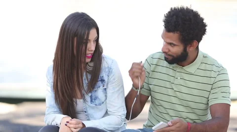 Happy couple listening to music together, sharing earphones Video stock 59555578