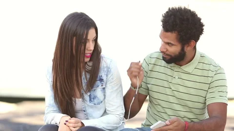 Happy couple listening to music together, sharing earphones Stock Footage 59555582