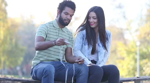 Happy couple listening to music together, sharing earphones Stock Footage 59555730