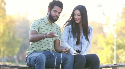 Happy couple listening to music together, sharing earphones Stock Footage 59555731