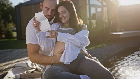 Happy Pregnant Woman and Her Husband Looking Ultrasound Scan Photo