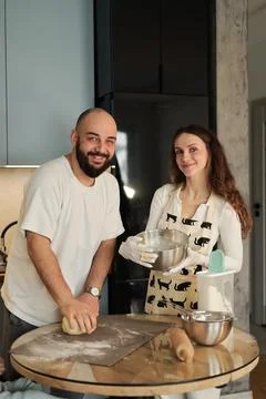 Happy Couple Looking at Camera While Baking Together Stock-Fotos