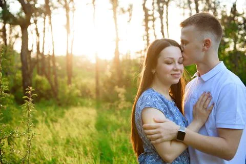 Happy couple in love in springtime at sunset. Woman and man holding hands and Stock Photos