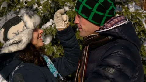 A happy couple of lovers walks through the snow-covered forest. They stand near Video stock 100764111
