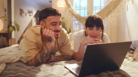 Happy Couple Lying on Bed and Watching Video on Laptop at Home Stock Footage 265032353