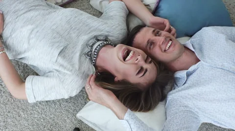 Happy couple lying head to head on a floor Stock Footage 64107750