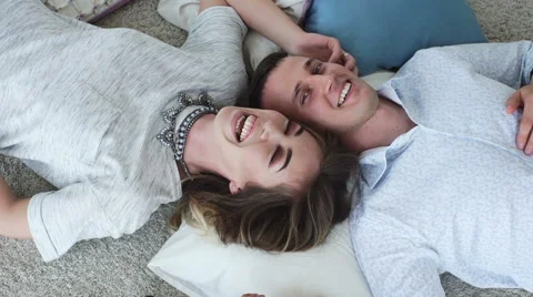 Happy couple lying head to head on a floor Stock Footage 64107815