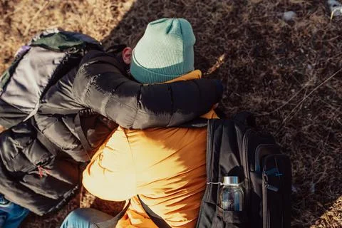 A happy couple lying on a meadow while resting on top of a mountain Foto stock