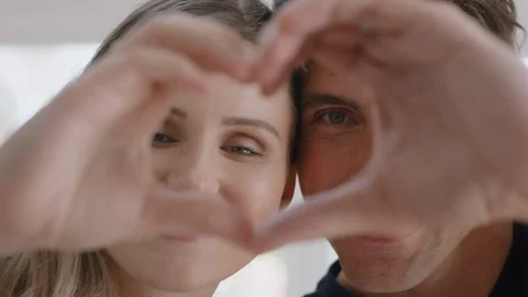 Happy couple making heart shape with hands gesturing romantic commitment 库存影片 109507839