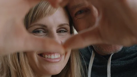 Happy couple making heart shape with hands gesturing romantic commitment 库存影片 111710955