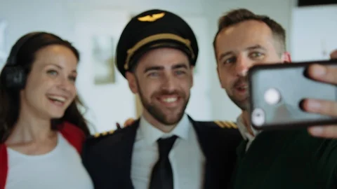 Happy couple making selfie with pilot at airport lounge. Cinematic shot on RED Video stock 109287084