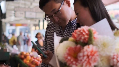 Happy Couple At Market Using Cell Phone Stock Footage 116753734