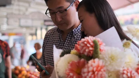 Happy Couple At Market Using Cell Phone 2 Stock Footage 116753780