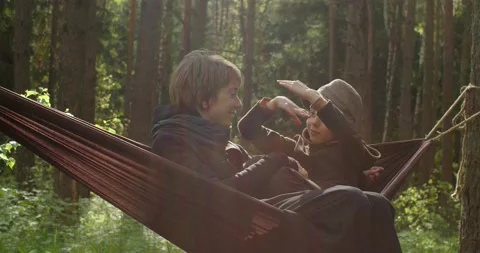 Happy couple mother kid relaxing in hammock in green coniferous forest slow Stock Footage 155953353