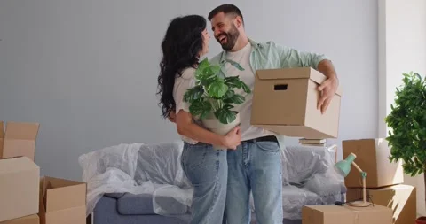 Happy couple moving carton boxes indoors, unpacking new home, standing together Stock Footage 325959796