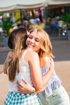 Happy couple or girl friends hugging after meeting Stock Photos
