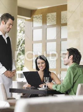 Happy Couple Ordering Meal To Waiter Stock Photos