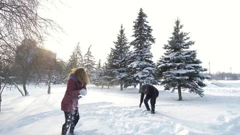A happy couple playfully spends time in a winter park having fun on a snowy Stock Footage 162096990