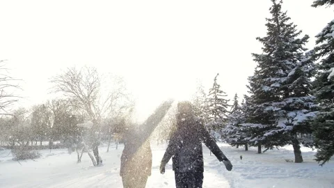 A happy couple playfully spends time in a winter park having fun on a snowy Stock Footage 162668025