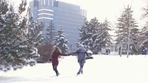 A happy couple playfully spends time in a winter park having fun on a snowy Stock Footage 162671566