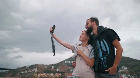 Happy couple posing taking selfie at beach coastline resort enjoy travel Stock Footage 224970464